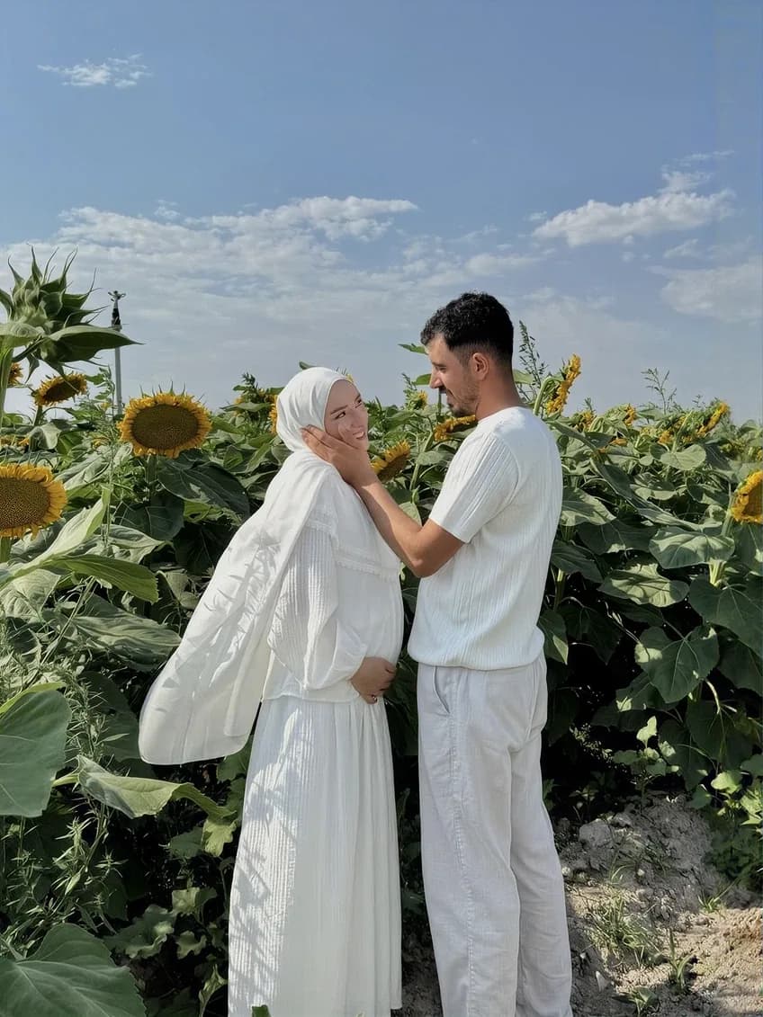 Una coppia appena sposata l'una di fronte all'altra in un campo di girasoli