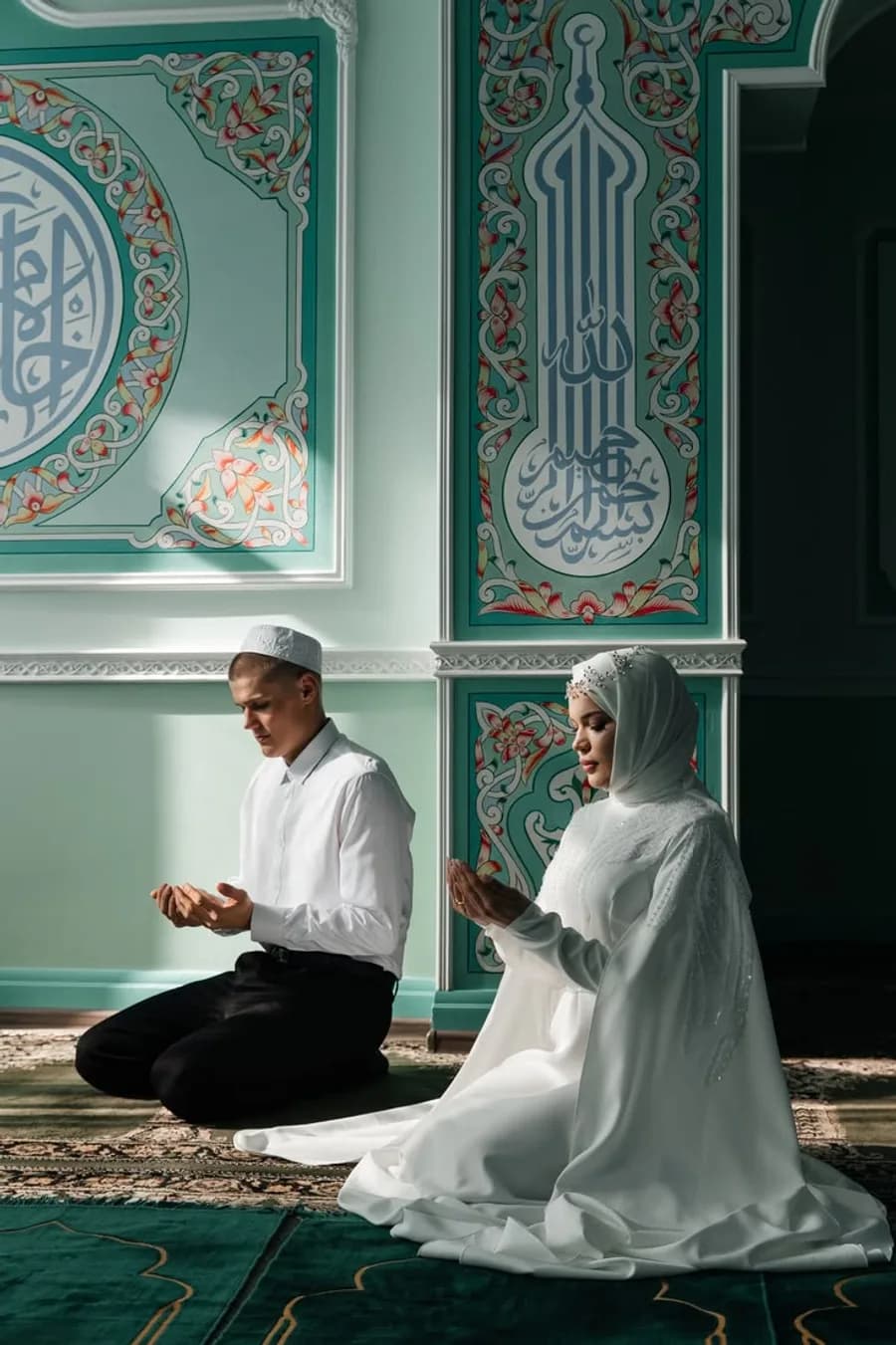 A newly married couple standing together outside a mosque